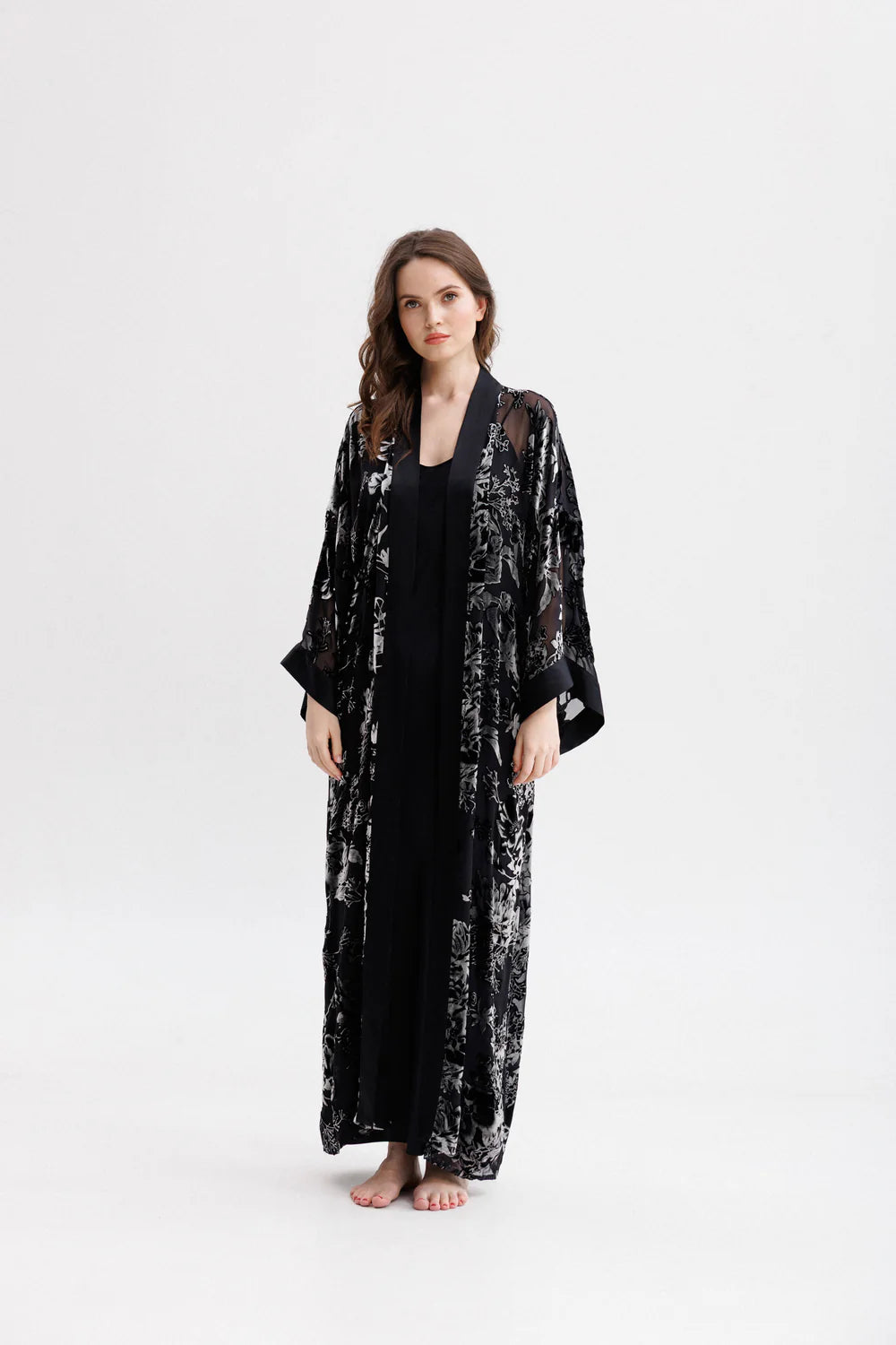 Woman wearing a black floral silk velvet kimono. Front full picture