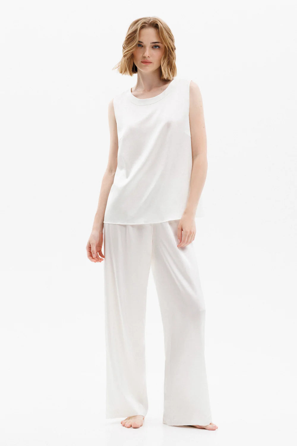 Woman wearing a white silk sleeveless top (sold separately) and white silk pants showing the front