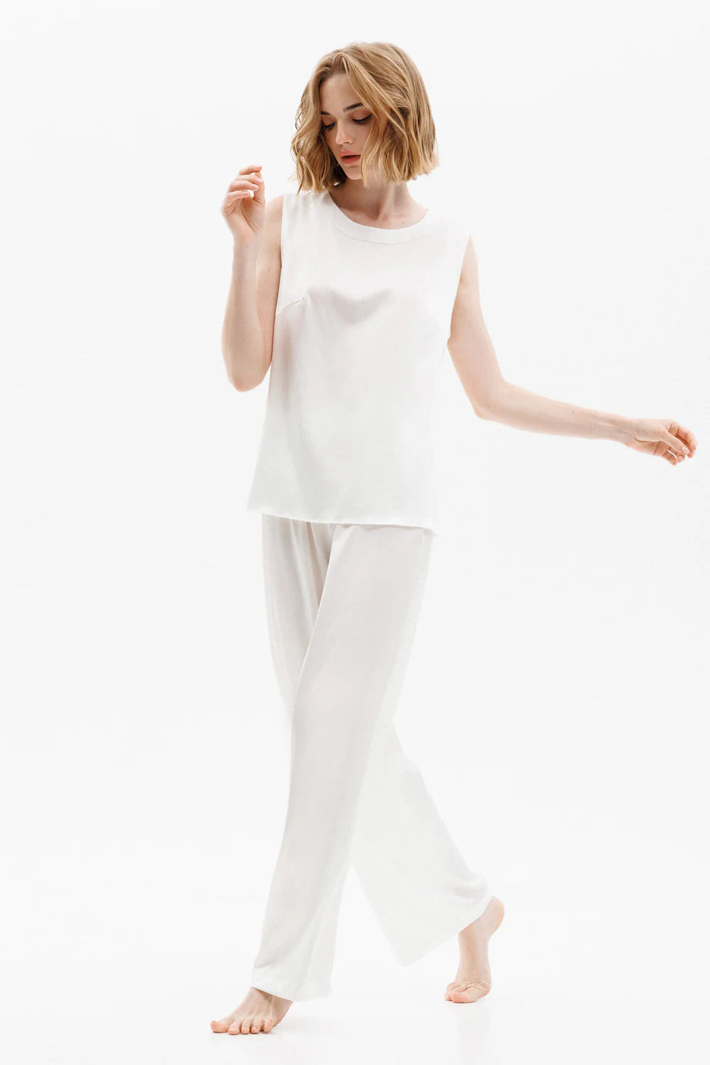 Woman wearing a white silk sleeveless top (sold separately) and white silk pants showing the front