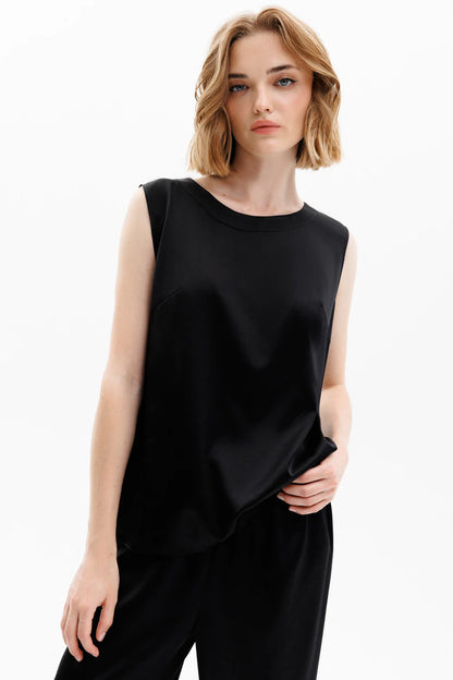 Woman wearing a black silk sleeveless top and black silk pants (sold separately) 