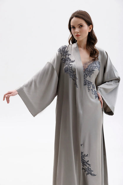 Woman wearing a gray silk nightgown with lace detailing (sold separately) and a matching elegant silk robe . Showing the elegancy of the sleave